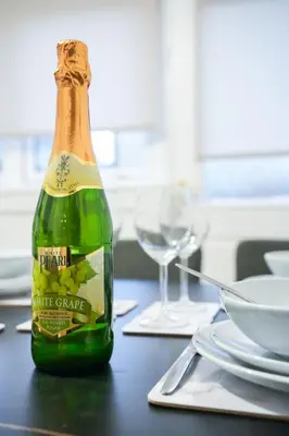 a bottle of champagne sitting on a table with glasses at Sedgebank House in Livingston