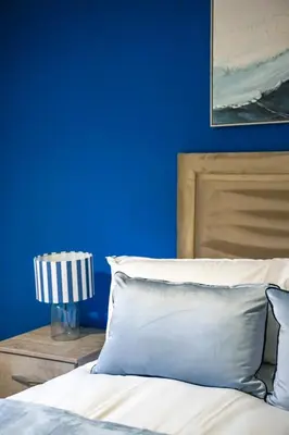 a blue bedroom with a bed and a blue wall at Sedgebank House in Livingston