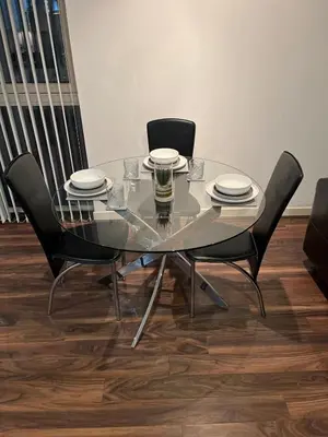 a glass table with two chairs and plates on it at City centre luxury apartment in Glasgow
