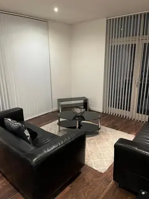 a living room with a leather couch and a table at City centre luxury apartment in Glasgow