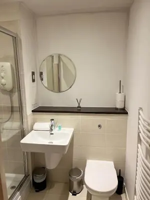 a bathroom with a sink and a toilet and a mirror at City centre luxury apartment in Glasgow