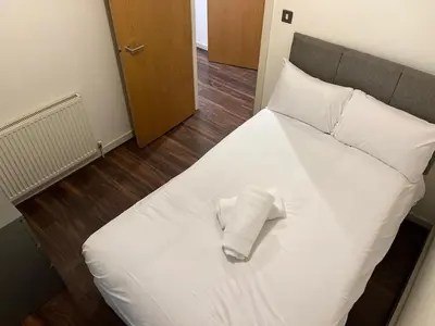 a white bed with a pillow on top of it at City centre luxury apartment in Glasgow