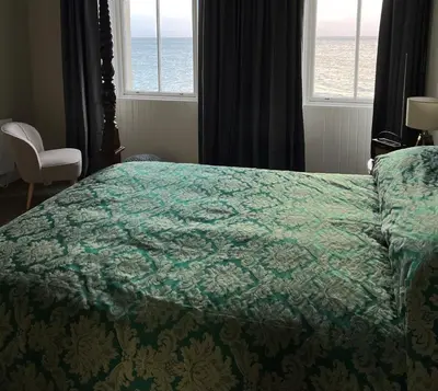 a bedroom with a bed and a window with the ocean at The Corrie Hotel in Corrie
