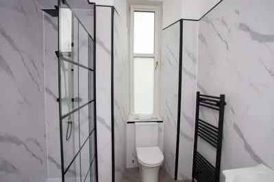 a white bathroom with a toilet and a window at Stylish Southside 2 Bedroom Flat with Free Parking in Glasgow