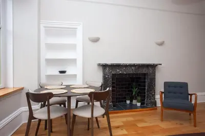 a dining room with a table and chairs and a fireplace at Stylish Southside 2 Bedroom Flat with Free Parking in Glasgow