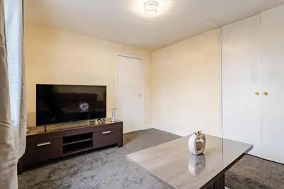 a living room with a television and a table at Cosy Retreat Suites in Hamilton
