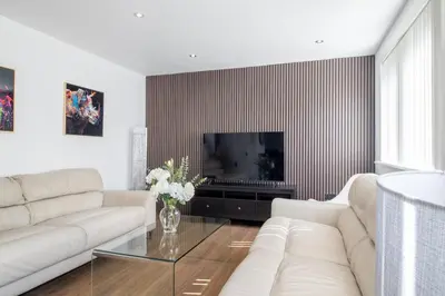 a living room with a white couch and a television at The Kings Height close to Glasgow and Edinburgh in Airdrie