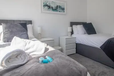 a bedroom with two beds with blue blocks on the bed at The Kings Height close to Glasgow and Edinburgh in Airdrie
