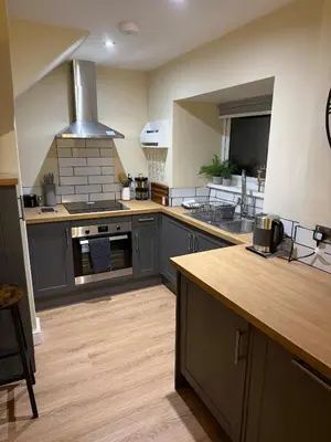 a kitchen with gray cabinets and a stove top oven at Corner House, newly refurbished, Dunning in Dunning