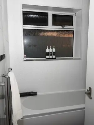 a bathroom with a tub and two bottles on a window at The Telford Nook in Edinburgh