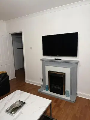 a living room with a tv on top of a fireplace at The Telford Nook in Edinburgh