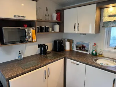 a kitchen counter with a sink and a microwave at Turnberry Holiday Park Amazing Sea View in Girvan