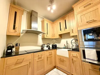 a kitchen with wooden cabinets and black counter tops at Cozy 1 bed Garden flat in the New Town City Centre in Edinburgh