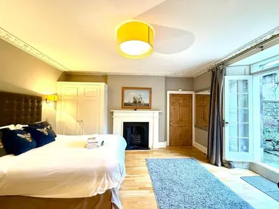 a bedroom with a large bed and a fireplace at Cozy 1 bed Garden flat in the New Town City Centre in Edinburgh