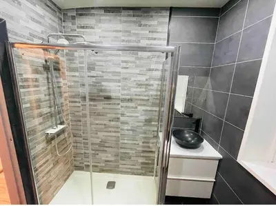a shower with a glass door in a bathroom at Large double room in a house at Glasgow Westend in Knightswood
