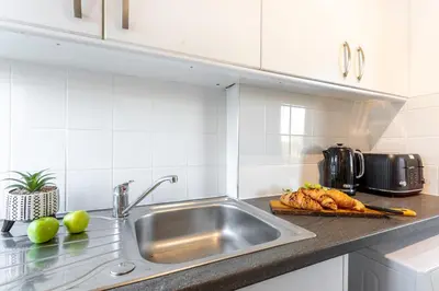a kitchen counter with a sink and a plate of bread at Cosy 3 bed home in Cardonald G52 in Cardonald