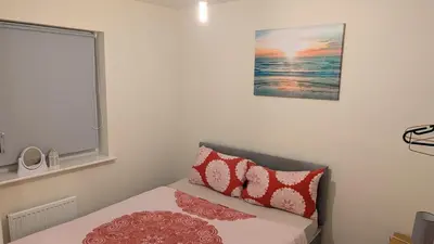 a bedroom with a bed and a picture of the ocean at NG Property in Glasgow