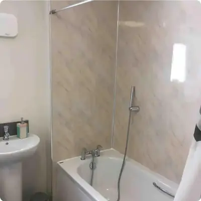 a bathroom with a shower with a tub and a sink at NG Property in Glasgow