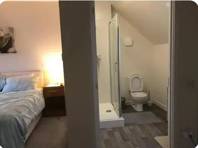 a bedroom with a bed and a shower and a toilet at NG Property in Glasgow