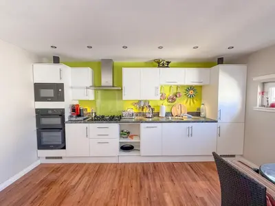 a kitchen with white cabinets and yellow walls at Marina View Apartment with Balcony & Sea Views in Horse Isle