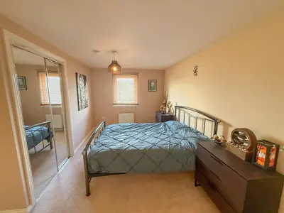 a bedroom with a bed and a dresser and a mirror at Marina View Apartment with Balcony & Sea Views in Horse Isle