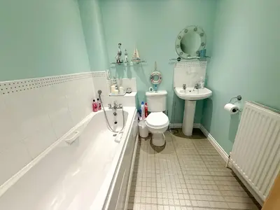 a bathroom with a toilet and a tub and a sink at Marina View Apartment with Balcony & Sea Views in Horse Isle