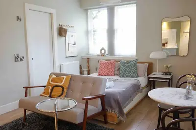 a living room with a couch and a table at Fully licensed studio in peaceful neighbourhood in Edinburgh