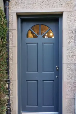 a blue door with a window on a building at Fully licensed studio in peaceful neighbourhood in Edinburgh