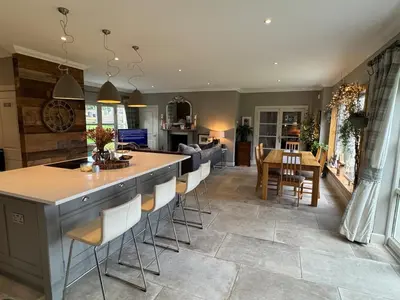 a kitchen and living room with a table and chairs at Borders Escape with Hot Tub in West Linton