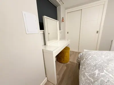 a bedroom with a dressing table and a bed at 2-Bed Flat in Glasgow East End in Glasgow
