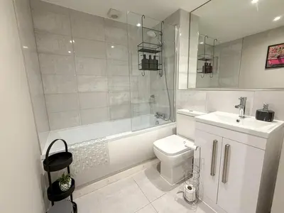 a bathroom with a toilet and a tub and a sink at 2-Bed Flat in Glasgow East End in Glasgow