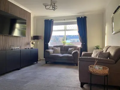 a living room with a couch and a television at 3BR Sleeps 6 Free Parking Near Glasgow City in Renfrew