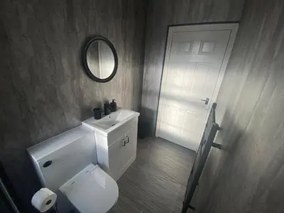 a bathroom with a white toilet and a mirror at 3BR Sleeps 6 Free Parking Near Glasgow City in Renfrew