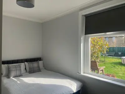a bedroom with a bed and a large window at 3BR Sleeps 6 Free Parking Near Glasgow City in Renfrew