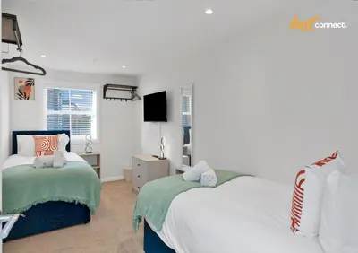a bedroom with two beds and a window at Central 2BR Flat at Wellwynd I Parking Included in Airdrie