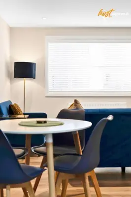 a room with a table and chairs and a window at Central 2BR Flat at Wellwynd I Parking Included in Airdrie