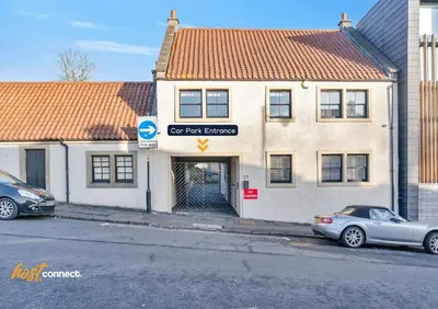 a car parked in front of a building at Central 2BR Flat at Wellwynd I Parking Included in Airdrie