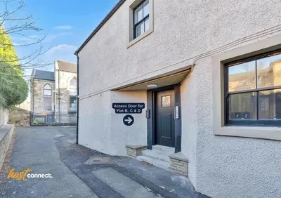 a building with a sign on the side of it at Comfy 1 Bed Airdrie Flat w Private Parking in Airdrie