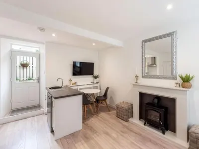a living room with a fireplace and a mirror at Meadow Hill Cottage with Private Garden, Crieff in Crieff