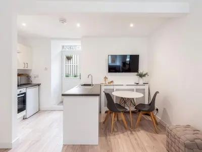 a kitchen with white walls and a table and chairs at Meadow Hill Cottage with Private Garden, Crieff in Crieff