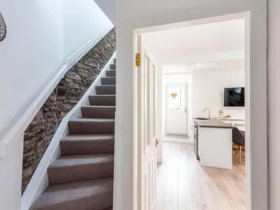 a staircase in a home with a stone wall at Meadow Hill Cottage with Private Garden, Crieff in Crieff
