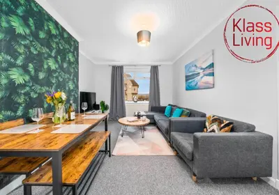a living room with a couch and a table at Mc Culloch Apartment by Klass Living Viewpark in Uddingston