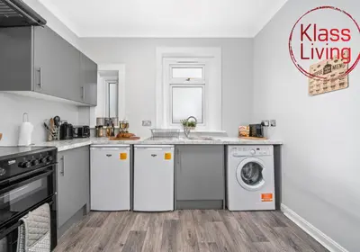 a kitchen with white appliances and a sink at Mc Culloch Apartment by Klass Living Viewpark in Uddingston