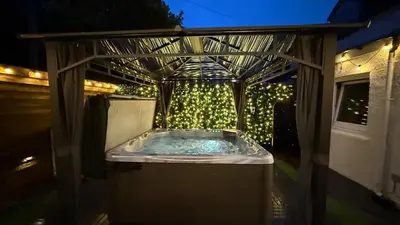 a hot tub in a gazebo with christmas lights at Welcome to your perfect getaway in Glasgow