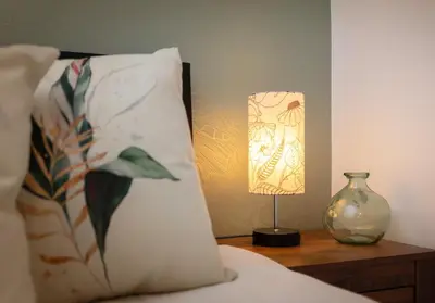 a table with a lamp and a pillow and a vase at Broomfield No 31 by Klass Living Airdrie in Airdrie