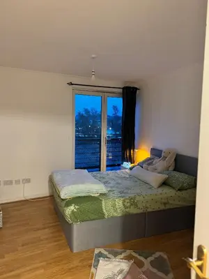 a bedroom with a bed and a large window at Skyline Serenity Cost Flat in Glasgow