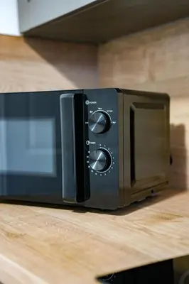 a black microwave sitting on top of a counter at Elm House in Bathgate