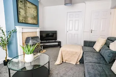 a living room with a couch and a tv at Elm House in Bathgate