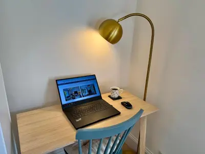 a laptop computer sitting on a desk with a lamp at Lochview Flat in Onich