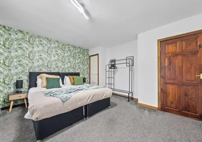 a bedroom with a bed and a wooden door at Elmbank Avenue House by Klass Living Uddingston in Uddingston